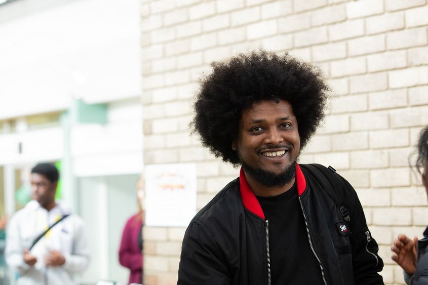 Smiling man wearing a black jacket with red collar Smiling man wearing a black jacket with red collar